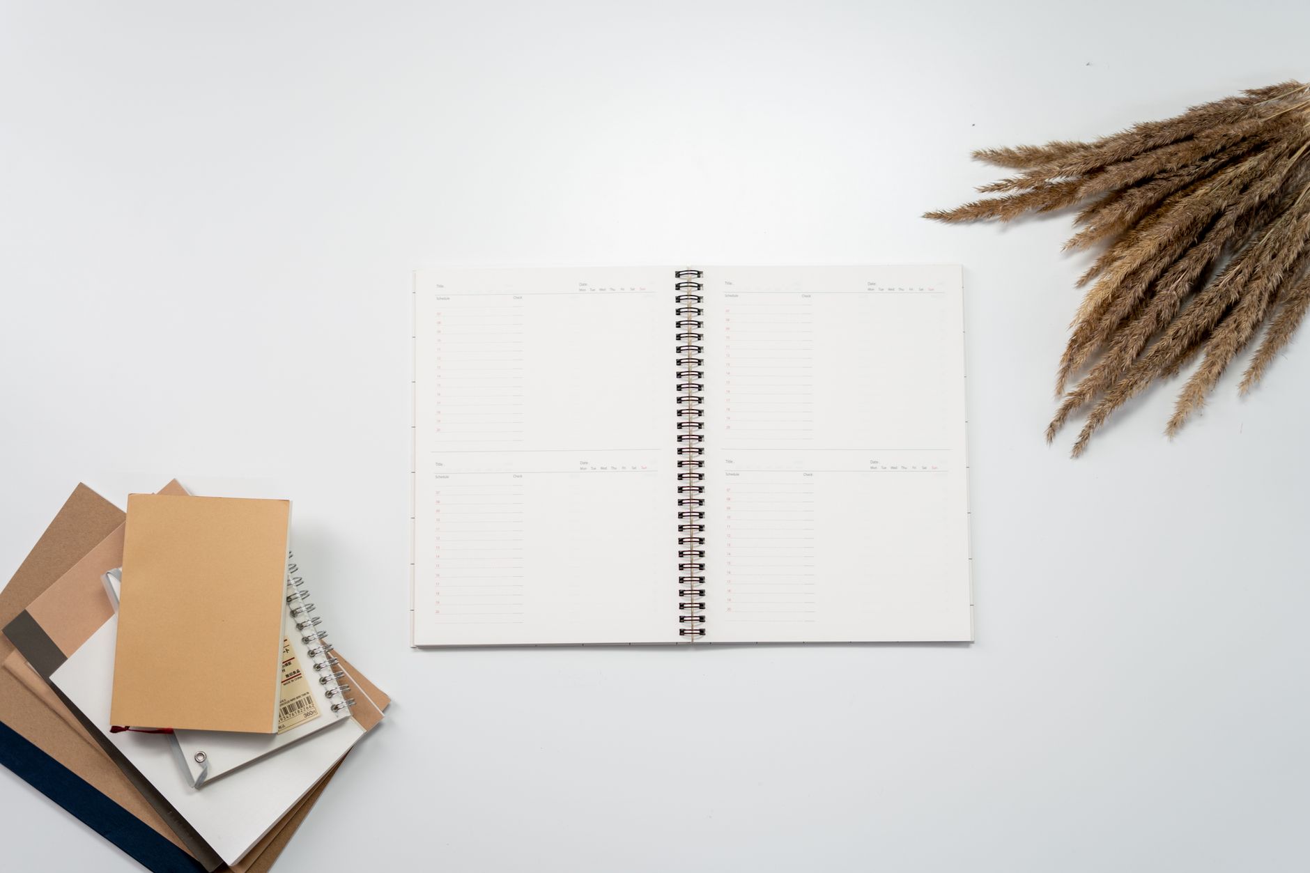 Notebook and calendar with a launch week planning list on a wooden desk